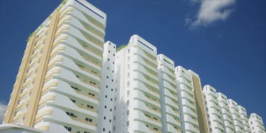 Modern white and beige apartment buildings under a clear blue sky.