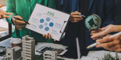 People discussing ESG initiatives with documents and globe models.