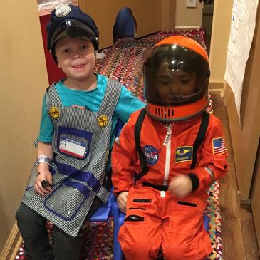 Milestones UWS Preschool - dramatic play with a train conductor and astronaut