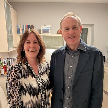 Two people smiling together in a kitchen setting.