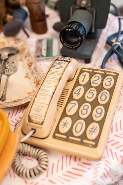 Vintage beige landline phone with large buttons and a directory on the handset.