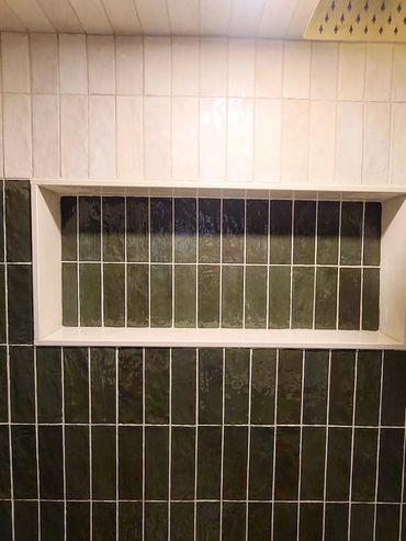 Rectangular recessed shelf with contrasting dark and light vertical tiles.