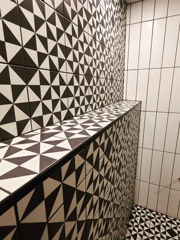 Black and white geometric patterned tiles on walls and floor.