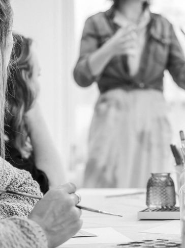 Woman holding paintbrush taking art class.
