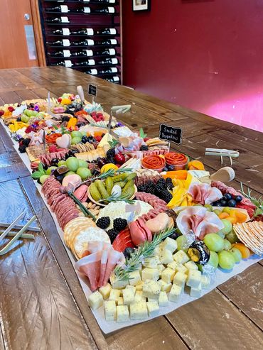 A vibrant charcuterie board with various meats, cheeses, fruits, and crackers.