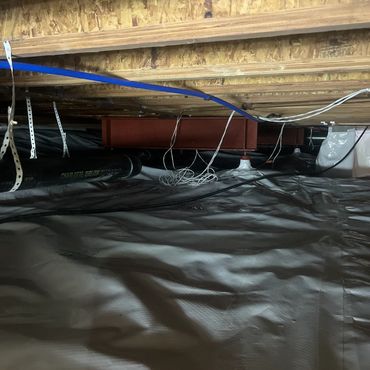 Encapsulated crawl space with moisture barrier, reinforced steel beams, and organized plumbing lines