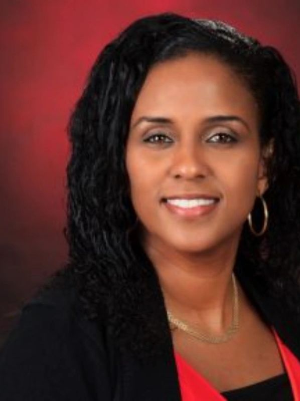 Professional woman smiling against a red background.