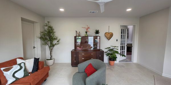 Modern living room with cozy seating and decorative plants.
