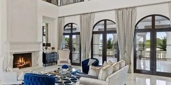 Elegant living room with blue and beige furniture and large arched windows.