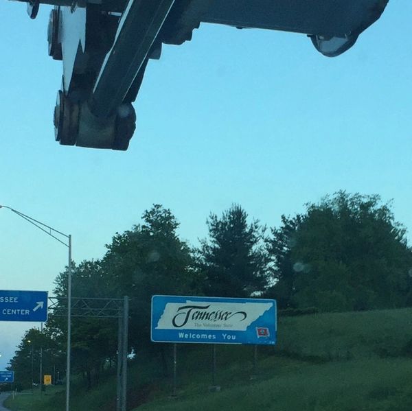 Bucket truck servicing "Welcome to Tennessee" road sign.