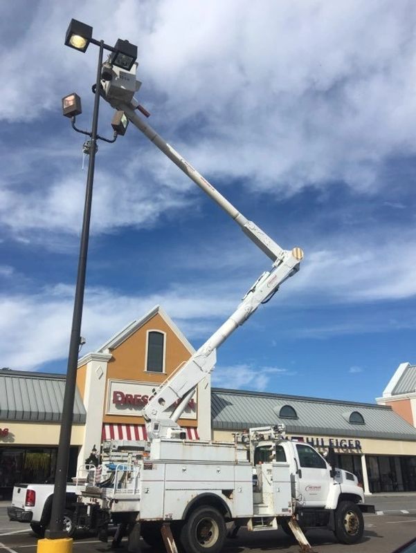 Bucket truck servicing parking lot light.