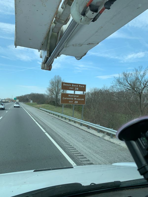 Bucket truck servicing "Beech Bend Park" road sign.
