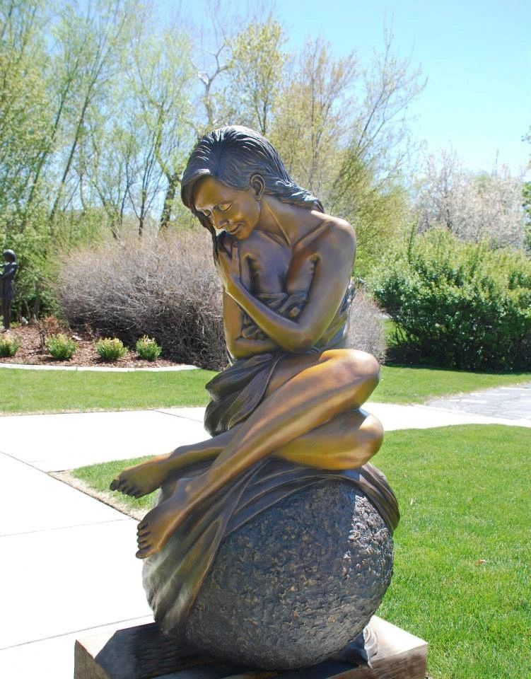 Solitaire bronze sculpture by J. Anne Butler displayed in luxury garden setting