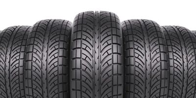 Four black car tires with detailed tread patterns lined up closely.
