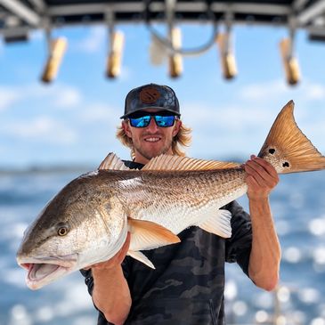 Man holding a large fish on a boat.