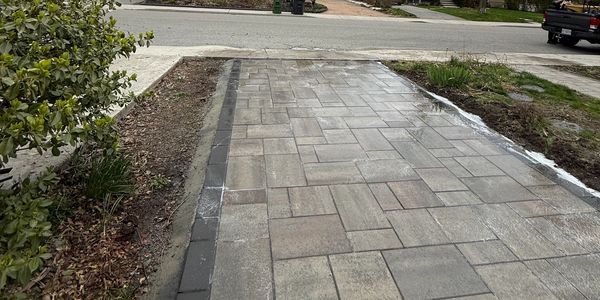 Newly paved concrete driveway with patterned tiles.