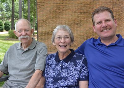 Three people smiling outdoors.