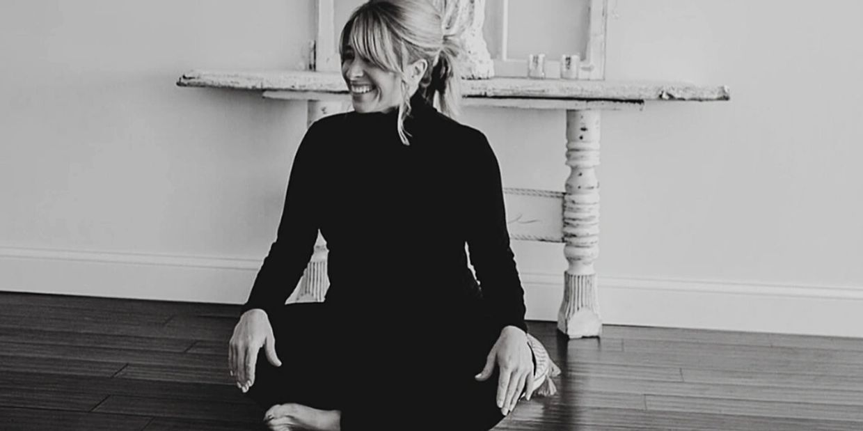 Kelly Mitchell sitting and smiling at Buddha Barn Yoga and Wellness