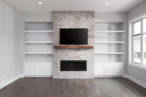 Fireplace accent wall with custom shelves and mounted tv