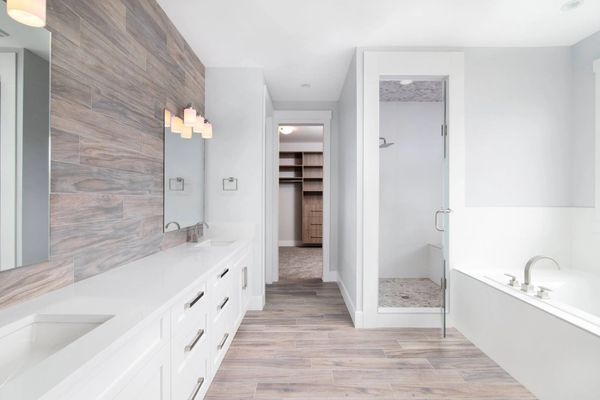 Custom walk-in closet with planked bathroom wall and walk-in shower