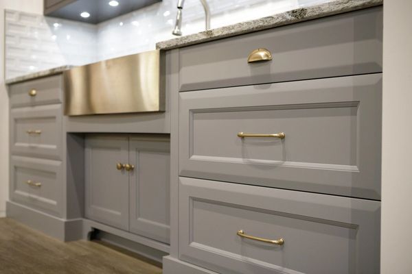 Grey kitchen cabinets with stainless steel hardware and kitchenaid sink