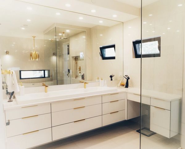 Floating bathroom vanity and cabinets with gold fixtures