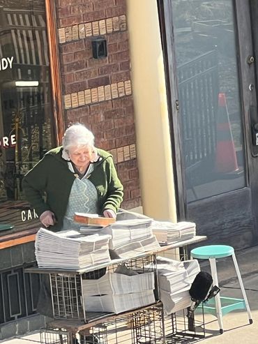 old lady is selling newspapers