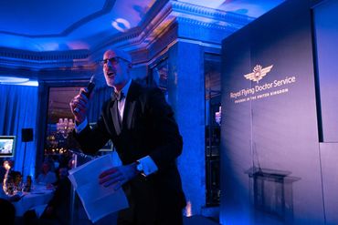 Man in tuxedo speaking at Royal Flying Doctor Service event.