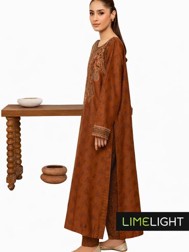 Woman wearing a brown traditional outfit with intricate patterns and embroidery.