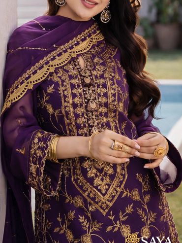 Elegant purple traditional dress with intricate gold embroidery and matching accessories.