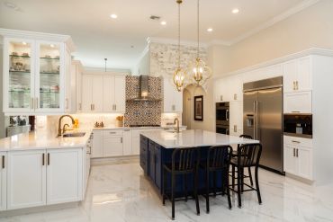 Bright modern kitchen with white cabinets and blue island.