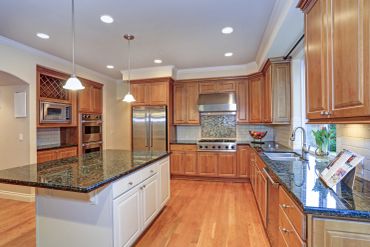 Modern kitchen with wood cabinets and granite counters.