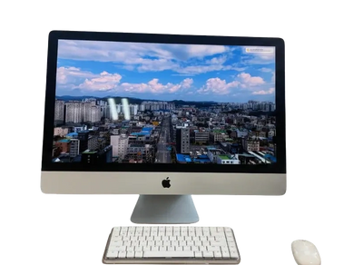 Apple iMac with wireless keyboard and mouse displaying a cityscape on screen.