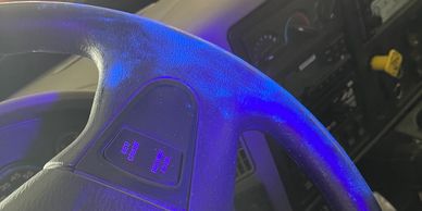 A steering wheel of a fire engine with contamination shown under UV lighting