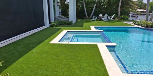 Modern swimming pool with green artificial grass.