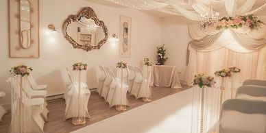 Elegant wedding ceremony setup with roses and draped curtains.