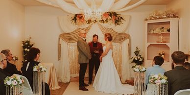 Intimate indoor wedding ceremony with bride and groom.