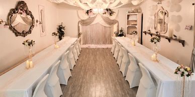 Elegant banquet setup with white decor and floral arrangements.
