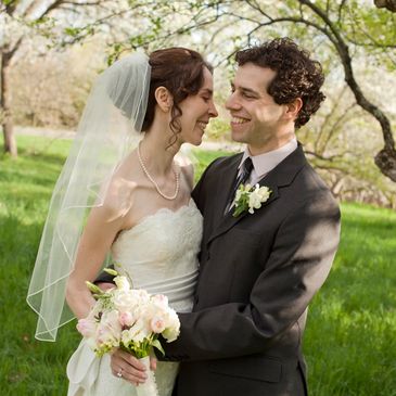 A photograph of a bride and a groom in a park.