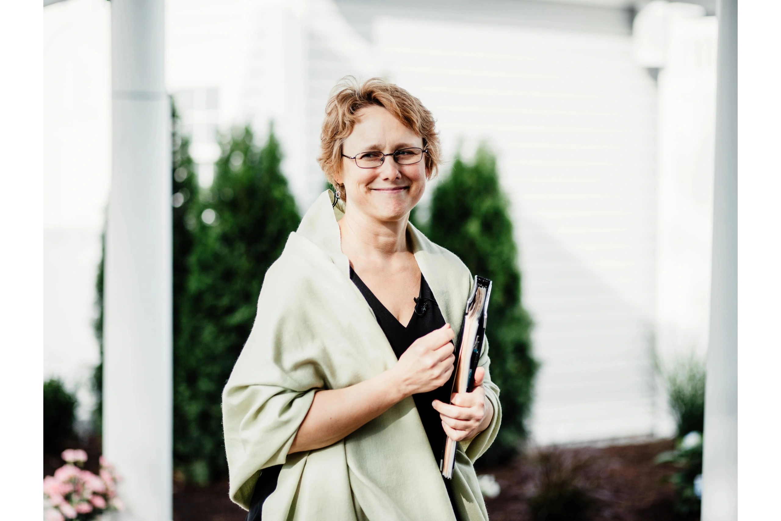 A photograph of a wedding officiant with a binder.