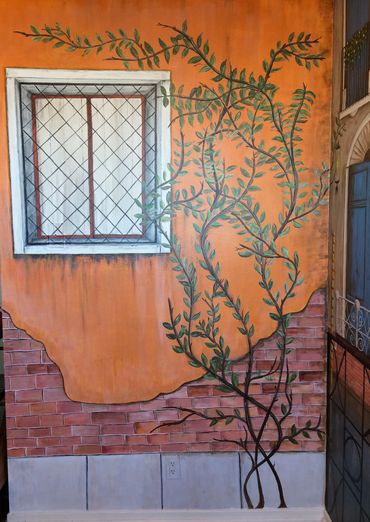 Mural by Dalia Garcia wall in Venice, Italy. Old Brick building with window, vine