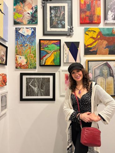 a woman standing in front of a wall of art