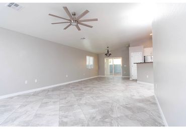 Spacious empty room with tiled floor and ceiling fans.