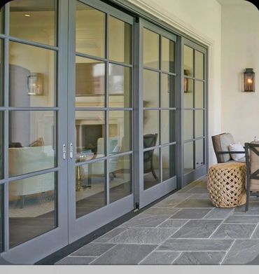 Elegant glass sliding doors open to a cozy, stylish patio seating area.