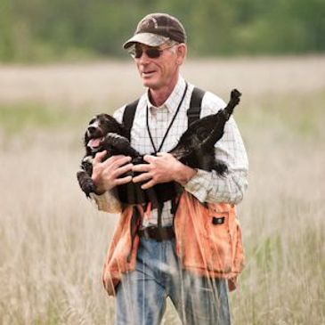 man holding dog in field