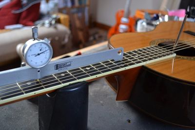 An acoustic guitar on the work bench, getting a setup and truss rod adjustment. 