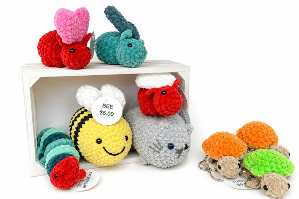 Colorful crocheted animal keychains including bunnies, bees, and turtles.