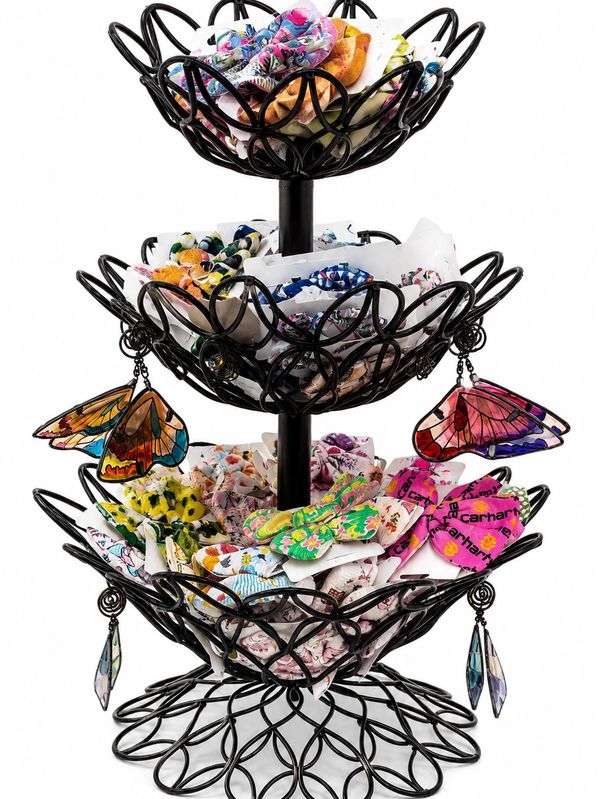 Three-tiered black metal stand with colorful fabric butterflies and flowers.
