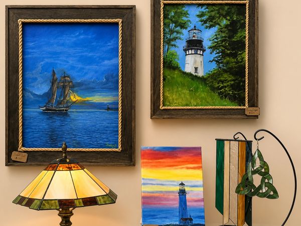 Paintings of lighthouses and a ship with decorative lamps below them.
