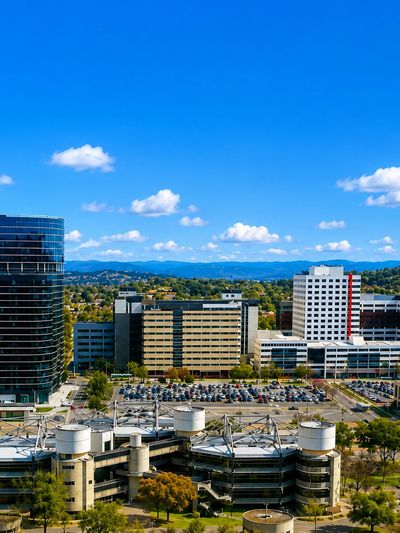 Cityscape with modern and urban buildings under a blue sky.